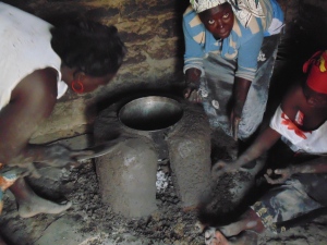 Haddie Ngom (left), Ami Diouf (center), and Mariama Diouf (right) nearly finished with a stove. The base and smoke holes remain.